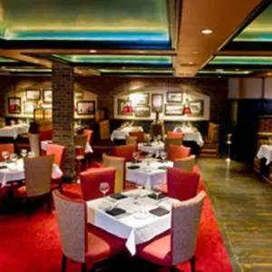 a dining room with tables and chairs in a restaurant at Carson Valley Motor Lodge and Suites in Minden