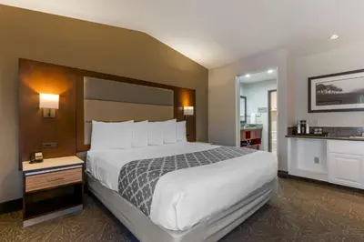 a hotel room with a large bed and a bathroom at Best Western Plus Forest Park Inn in Gilroy