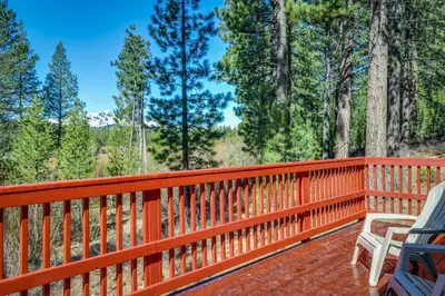 a wooden deck with a bench and trees at Cozy Seclusion in South Lake Tahoe