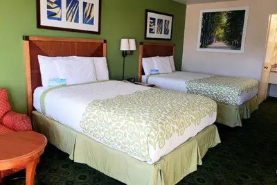 a hotel room with two beds and a chair at Days Inn by Wyndham Westley in Westley