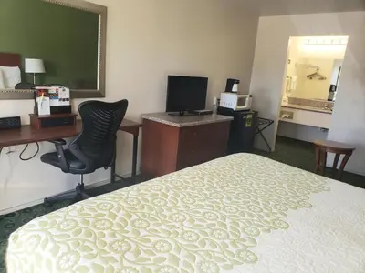 a hotel room with a bed and a desk and a computer at Days Inn by Wyndham Westley in Westley