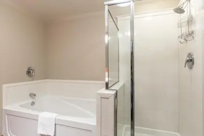 a white bathroom with a tub and a shower at Village 1401 in Mammoth Lakes