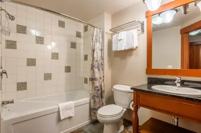 a bathroom with a tub and a toilet and a sink at Village 1401 in Mammoth Lakes