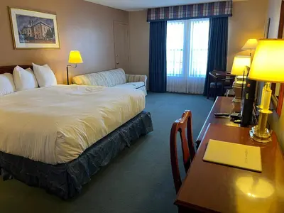 a hotel room with a bed and a desk with a laptop at Hardman House in Carson City