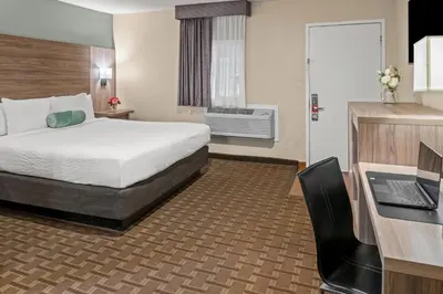 a hotel room with a bed and a desk with a laptop at Buck Meadows Lodge in Groveland