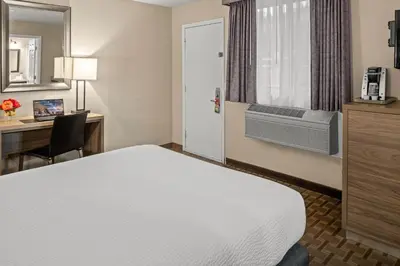 a hotel room with a bed and a desk with a computer at Buck Meadows Lodge in Groveland