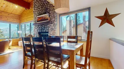a dining room with a table and chairs and a fireplace at Bridges Townhome #11 Townhouse in Mammoth Lakes