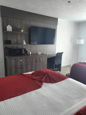 a hotel room with a bed and a flat screen tv at Sequoia Inn in Hanford
