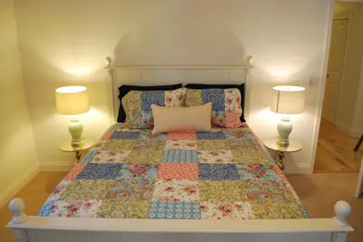 a bedroom with a bed with a quilt and two lamps at Big Tom's Cabin by Yosemite, lake and trails in Groveland