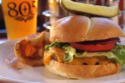 a sandwich on a plate with a pickle on top at The Pines Resort & Conference Center in Bass Lake