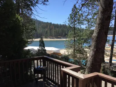 a wooden deck with a view of a lake at The Pines Resort & Conference Center in Bass Lake