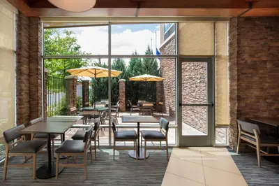 a restaurant with tables and chairs and large windows at Hyatt Place Reno/Tahoe Airport in Reno