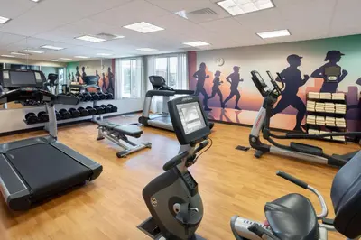 a gym with exercise equipment and a wall with a mural at Hyatt Place Reno/Tahoe Airport in Reno