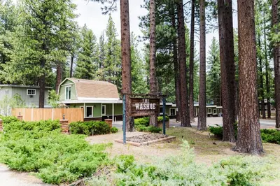a sign in front of a house with trees at The Washoe Lodge in South Lake Tahoe