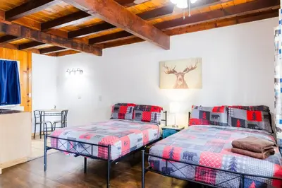 two beds in a room with wooden ceilings at The Washoe Lodge in South Lake Tahoe