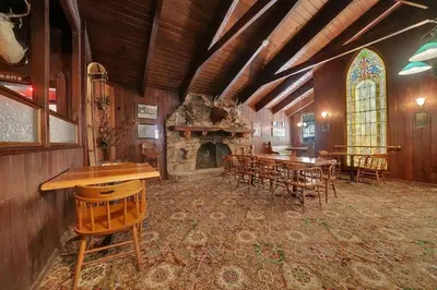 a large room with a fireplace and tables and chairs at Narrow Gauge Inn in Fish Camp