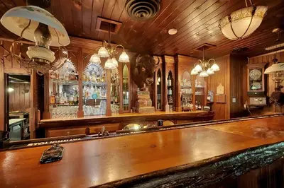 a bar with a long wooden counter in a room at Narrow Gauge Inn in Fish Camp