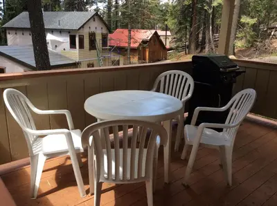 a white table and chairs on a porch with a grill at Jumping Deer in Yosemite West
