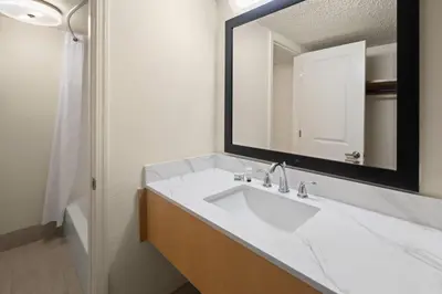 a bathroom with a white sink and a mirror at Ramada by Wyndham Merced in Merced