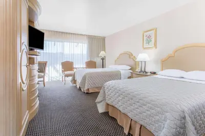 a hotel room with two beds and a television at Days Inn by Wyndham Modesto in Modesto