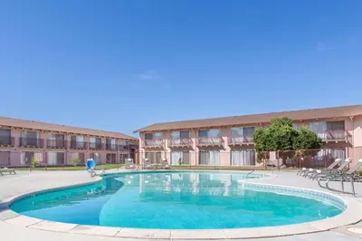 a large swimming pool in front of a building at Days Inn by Wyndham Modesto in Modesto
