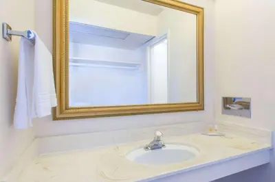 a bathroom with a sink and a mirror at Days Inn by Wyndham Modesto in Modesto