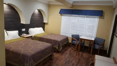 a hotel room with two beds and a table and chairs at Reedley Inn in Reedley