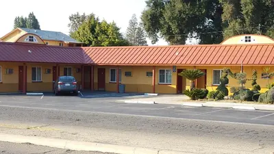 a car parked in a parking lot in front of a motel at Reedley Inn in Reedley