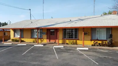 a building with a parking lot in front of it at Reedley Inn in Reedley