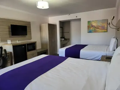 a hotel room with two beds and a flat screen tv at Death Valley Inn in Beatty