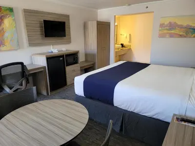 a hotel room with a large bed and a table at Death Valley Inn in Beatty