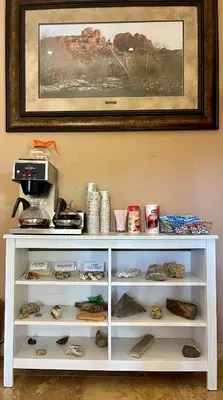 a white shelf with shoes and a picture on the wall at Death Valley Inn in Beatty