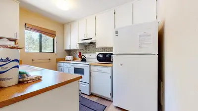 a kitchen with white cabinets and a white refrigerator at La Vista Blanc #61 Condo in Mammoth Lakes
