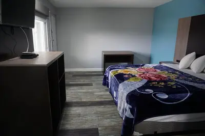 a hotel room with a bed and a dresser in it at Thunderbird Motel in Bishop