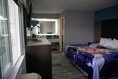 a hotel room with a bed and a window at Thunderbird Motel in Bishop