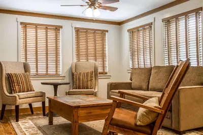 a living room with a couch and chairs and windows at Sierra Sky Ranch in Oakhurst