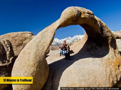 a man and a woman sitting on a rock formation at Cozy Muir Cottage - In Town - Pet Friendly in Lone Pine
