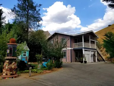 a house with a hill in the background at Sacred Mtn River Suites in Kernville