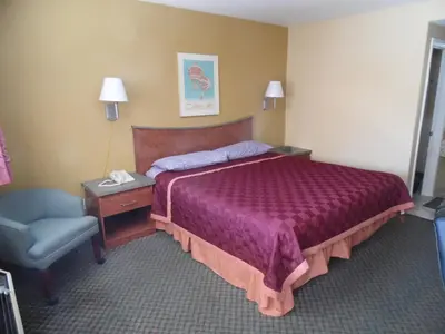 a hotel room with a bed and a chair at Trails Motel in Lone Pine