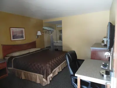 a hotel room with a bed and a table at Trails Motel in Lone Pine