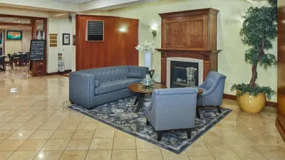 a living room with a couch and chairs and a fireplace at Lake Natoma Inn in Folsom