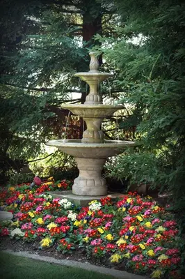 a fountain in the middle of a garden with flowers at Lake Natoma Inn in Folsom