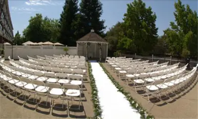 a row of chairs with white seats in a courtyard at Lake Natoma Inn in Folsom