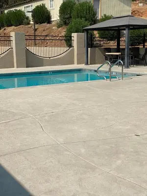 a swimming pool with a table and a umbrella at Country Inn Sonora in Sonora
