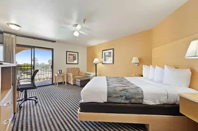 a hotel room with a bed and a balcony at Best Western Plus Executive Inn & Suites in Manteca