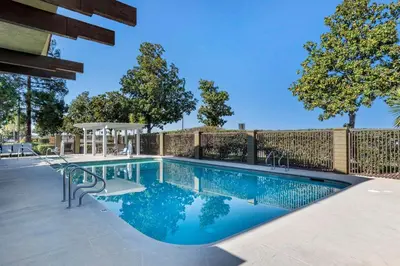 a swimming pool with a fence around it at Best Western Orchard Inn in Turlock