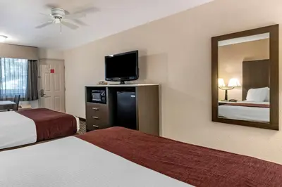 a hotel room with two beds and a mirror at Best Western Orchard Inn in Turlock