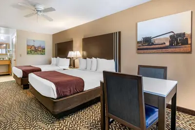 a hotel room with two beds and a desk at Best Western Orchard Inn in Turlock