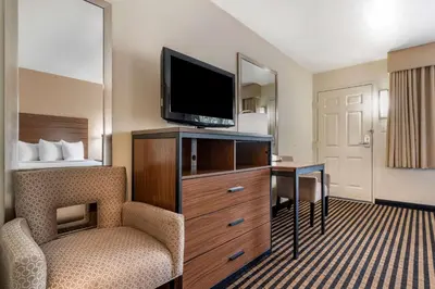 a hotel room with a television and a chair and a desk at Best Western Town House Lodge in Modesto