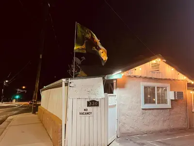 a flag flying on top of a building at night at Jumping Frog Motel in Angels Camp